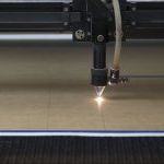 cutting machine carving patterns on the plastic plate. laser machine cutting pattern on acrylic sheet.